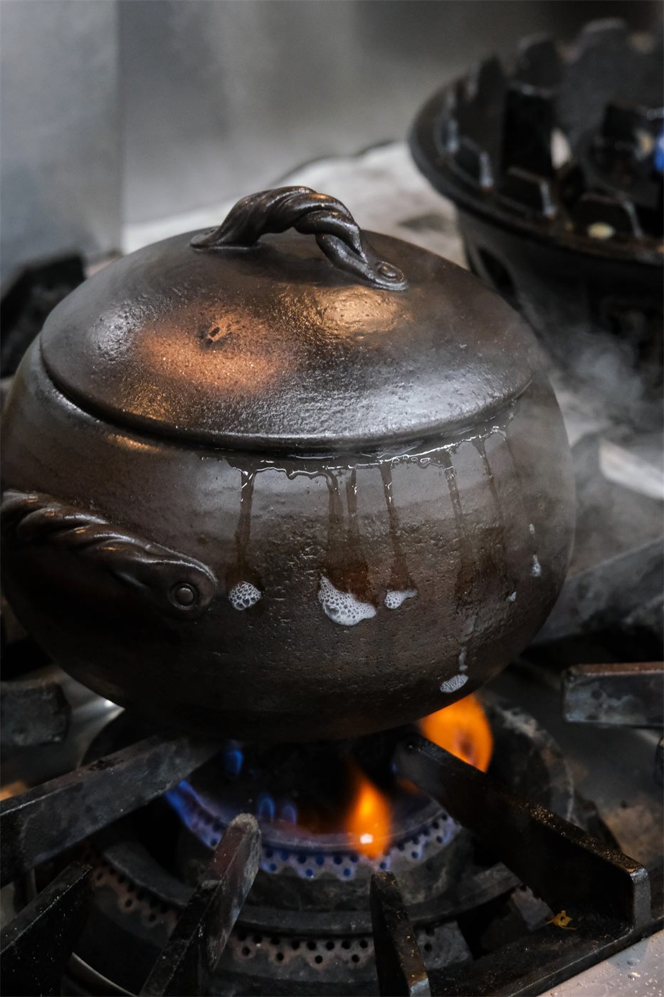 火にかけられ湯気をあげる羽釜