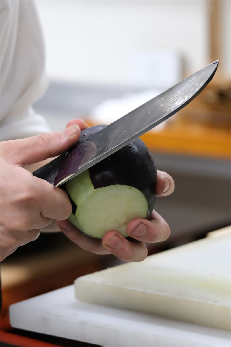 茄子に包丁を入れる手元